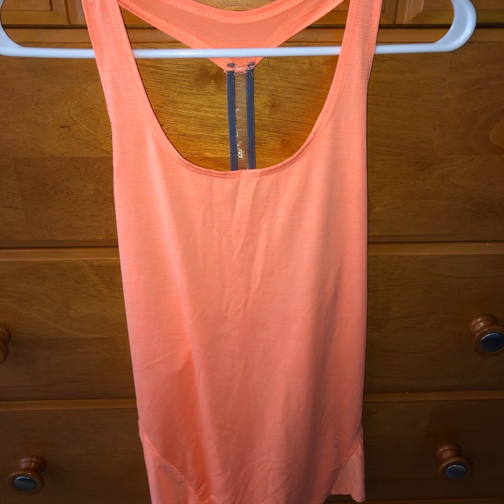 A peach or orange color tank top